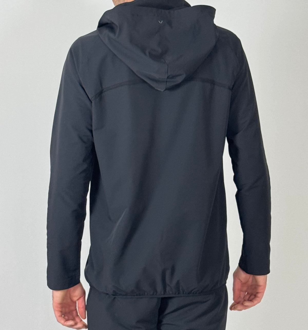 Rear close-up of the Antero black jacket, hood and hem